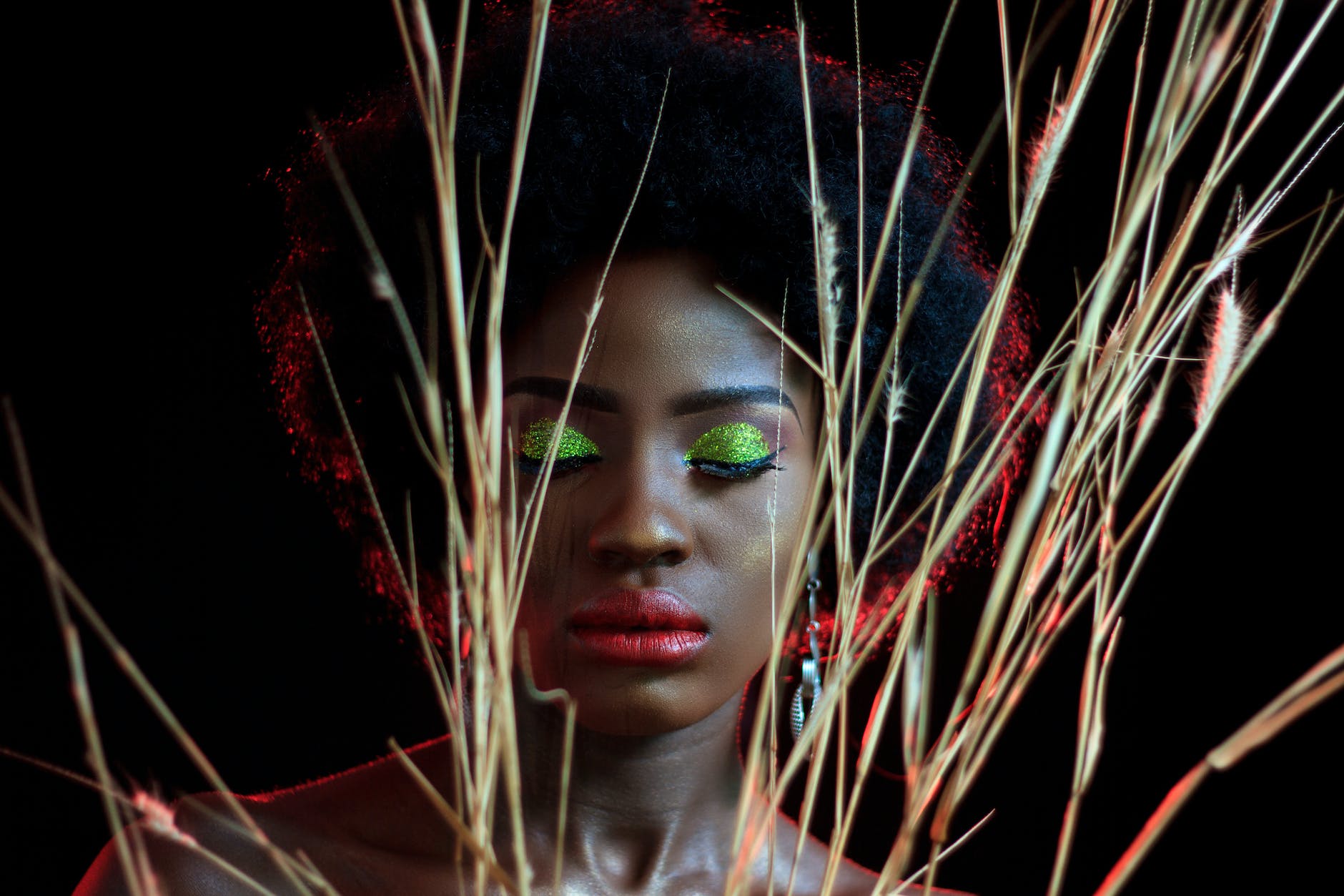 photo of a woman wearing makeup behind some wheat